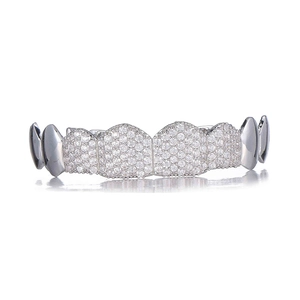 Macro detail of silver hip hop grillz with white zircon pavé and polished metal finish