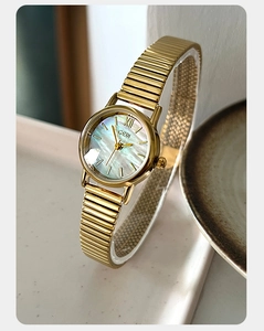 Close-up of GEDI watch with iridescent mother of pearl dial and gold stretch band