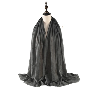 Dark grey crinkled cotton linen scarf for women with soft fringed edges on a model