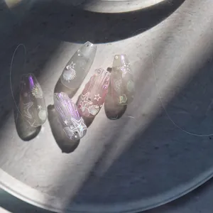 Detail of seashell nail art stickers featuring aurora finish and starfish accents