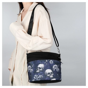 Gothic skull and floral print crossbody bag on model with adjustable strap and zip detail