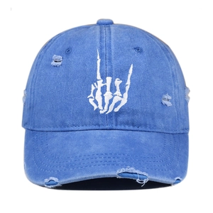 Detailed close-up of rock bone gesture embroidery on blue washed distressed baseball cap