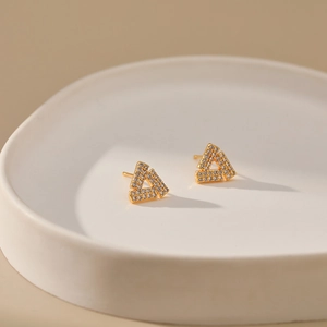 Macro shot of geometric triangle earrings with micro-pave cubic zirconia in gold