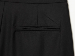 Gros plan détaillé sur le tissu en sergé noir et les coutures de précision de la poche de pantalon