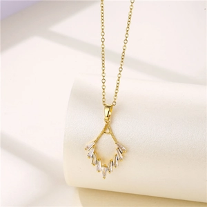 Detail of gold geometric necklace pendant featuring sparkling white zircon stone inlay