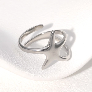 Detail of silver starfish ring with adjustable open band on a minimalist pedestal