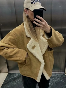 Veste en daim marron avec doublure et col en fausse fourrure blanche en selfie dans l'ascenseur