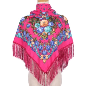 Detail of pink ethnic floral scarf showing vibrant patterns and long fringe tassels