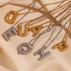 Detail van 3D-ballonletterhangers in goud en zilver op elegante kogelkettingen