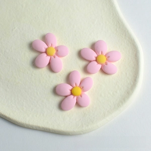 Close-up of three pink peach blossom resin charms for DIY hair accessories making