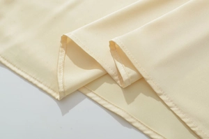 Vue macro des coutures d'ourlet et du tissu satiné lisse sur une robe d'été élégante