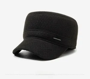Detail view of a brown wool flat top cap for men featuring a metallic Sports badge