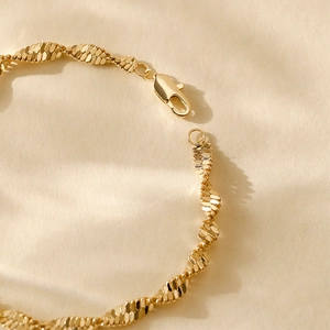 Detailed close-up of 14K gold plated bracelet showing twisted spiral scale texture