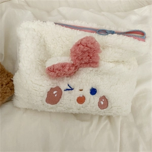 Close-up of plush rabbit storage bag with embroidery detail and pink bow decoration