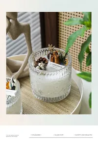 Detail of luxury glass jar scented candle with pine cones and cinnamon on a wooden tray