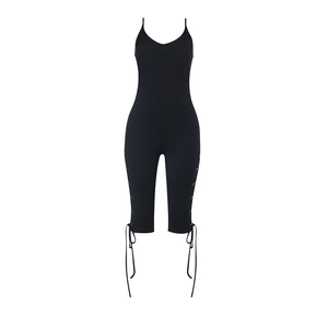 Detail of black slim-fit jumpsuit featuring side metal eyelets and lace-up straps