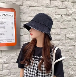 Vue latérale d'un chapeau bob en denim foncé avec bords effilochés sur un mannequin
