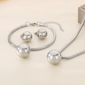 Macro detail of silver snake chain jewelry set with polished hollow spheres