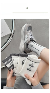 Détail de chaussettes en coton avec motifs cerises et typographie cherry pour femmes