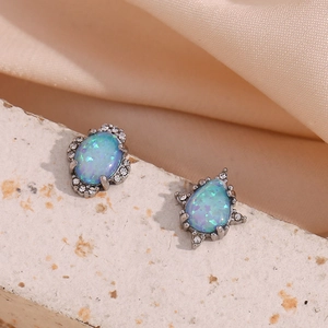 Gros plan de boucles d'oreilles opale avec pierres bleues irisées et cristaux