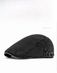 Detail of black denim beret with vintage texture and adjustable side metal buckle