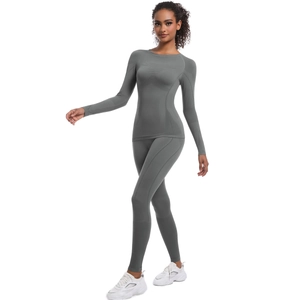 Set yoga grigio senza cuciture a vita alta con maniche lunghe e dettagli in maglia traspirante