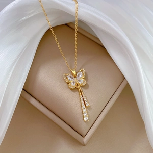 Elegant gold butterfly pendant necklace with sparkling rhinestones and tassels on display