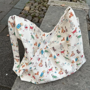 Detail of white canvas tote bag with cartoon dog prints on textured cotton fabric