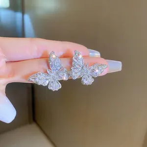 Handheld silver butterfly stud earrings with sparkling cubic zirconia pavé detailing