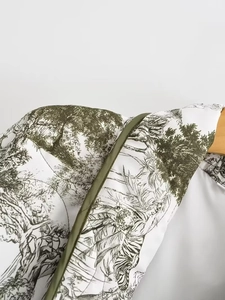 Détail de l'imprimé tigre Toile de Jouy sur veste matelassée blanche et bordure verte