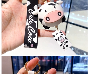 Detail of cute silicone cow keychain with heart pattern strap and golden ring