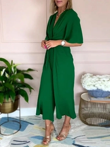 Detail of emerald green V-neck jumpsuit featuring waist tie and elegant wide-leg fit