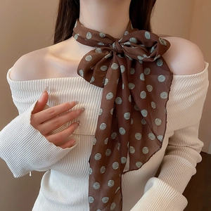 Detail of thin dark brown silk scarf with light blue polka dots on a white knit top