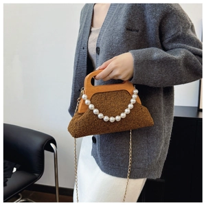 Detailed close-up of brown plush handbag featuring a wooden handle and pearl chain strap