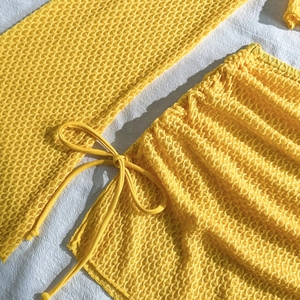 Dettaglio del tessuto giallo a nido d'ape con coulisse regolabile sul bikini