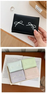 Close-up of elegant small wallets with bowknot and pearl details in multiple colors