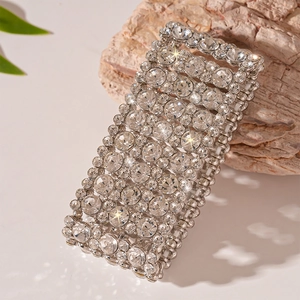 Close-up of wide silver elastic bracelet with multi-row crystals on natural stone