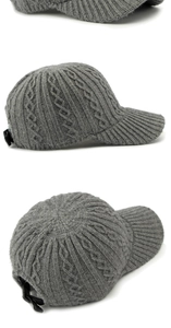 Detail of dark grey cable knit baseball cap featuring adjustable strap and ribbed texture