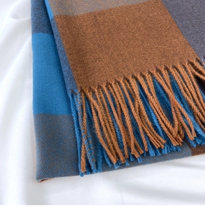 Detail of classic plaid scarf showing fine knit texture and soft fringe edges