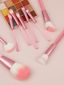 Detail of 9 professional makeup brushes with pink gradient bristles and transparent handles