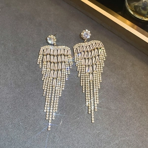 Detailed close-up of luxury sparkling zircon flower tassel earrings in silver finish