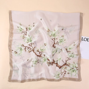 Detailed flat lay of elegant floral satin scarf with magnolia pattern and pearly sheen