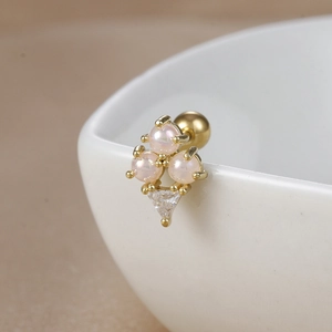 Macro detail of 18K gold stainless steel earrings with pink pearls and zircon stones
