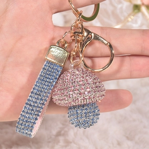 Sparkly mushroom keychain with pink and blue rhinestones on a gold metal ring