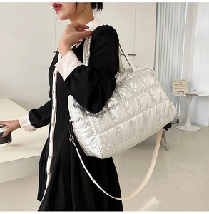 Silver quilted padded tote bag shown on model in a stylish studio setting