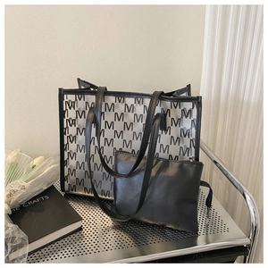 Detail view of transparent tote bag with M-pattern print and black inner PU pouch