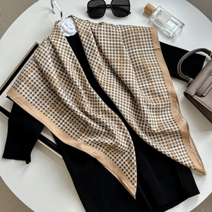 Elegant houndstooth silk scarf with brown border displayed with fashion accessories