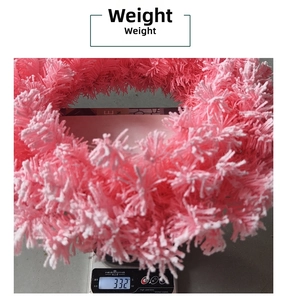 Pink plush Christmas wreath showing a weight of approximately 332g on a scale
