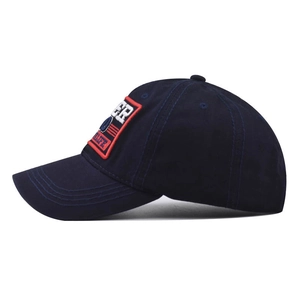Detalle del bordado en una gorra de béisbol de algodón azul marino con visera curva