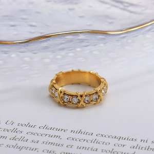 Elegant gold criss-cross ring with full crystals on paper and glass display